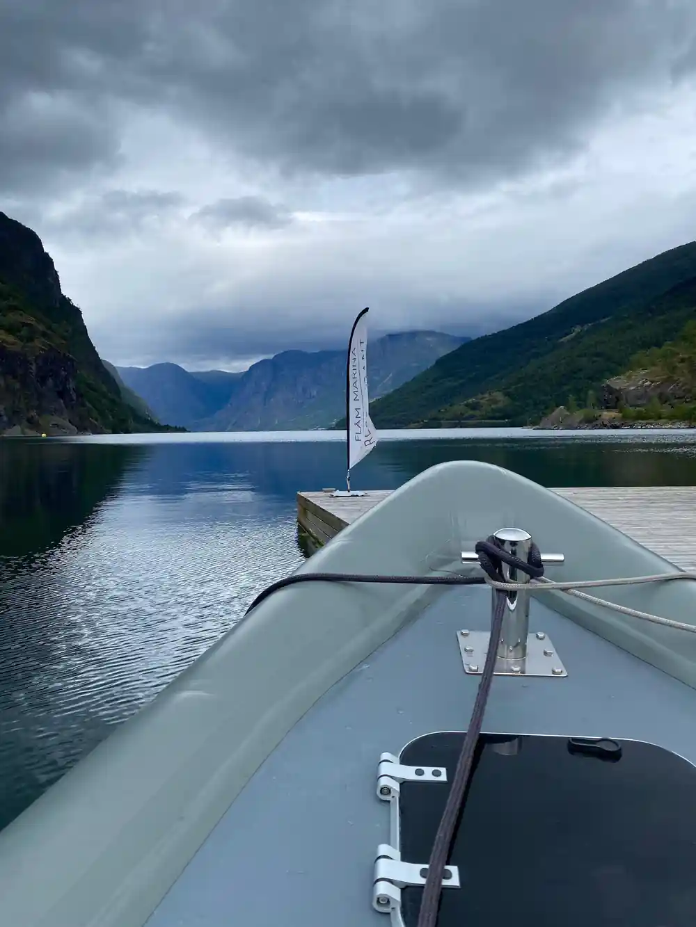 The bow of the boat and a flag on still water between the walls
