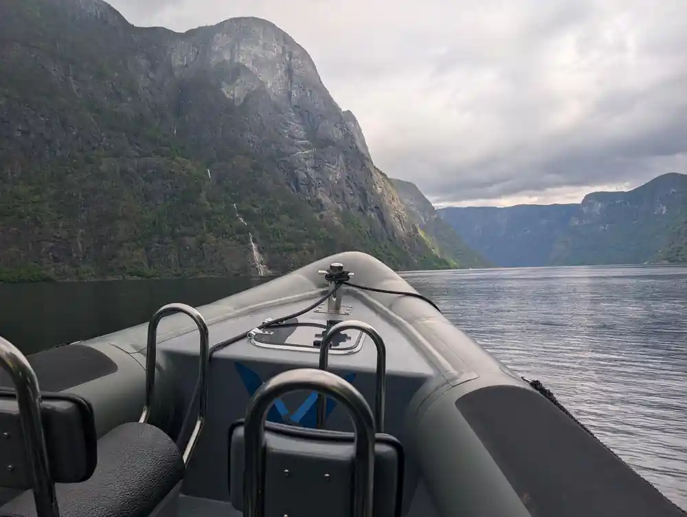The bow of the RIB with the fjord wall rising ahead