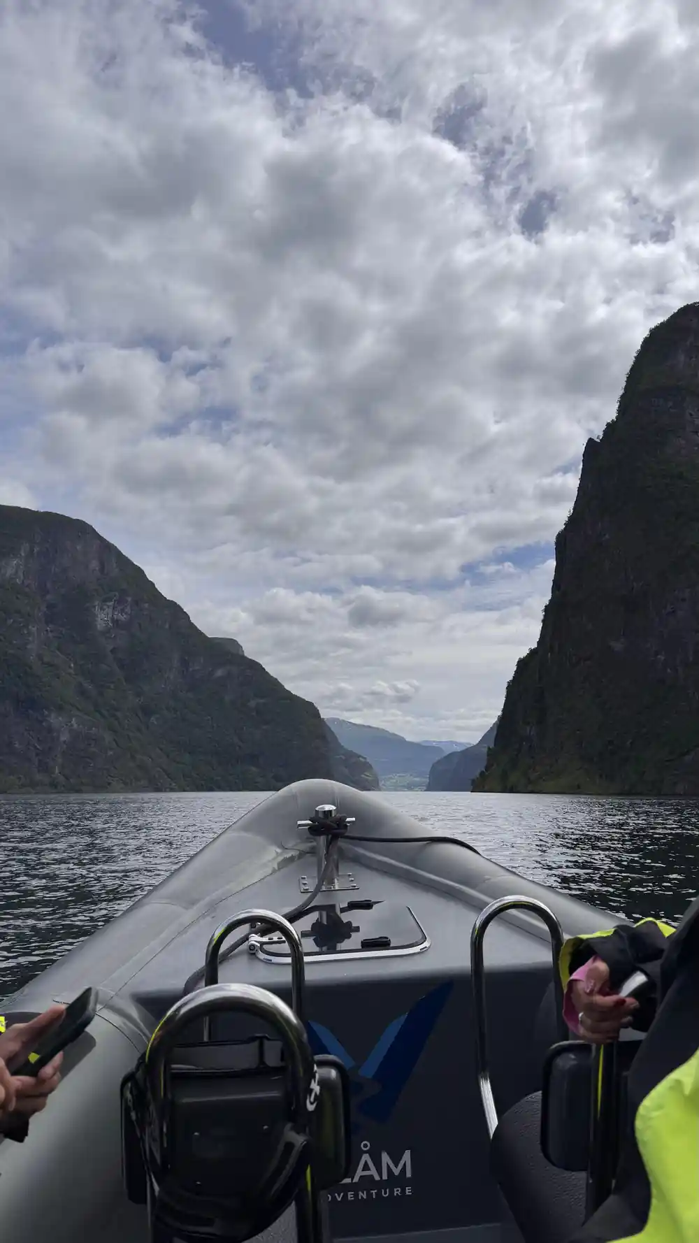 The bow of the RIB pointing down the fjord between vertical walls