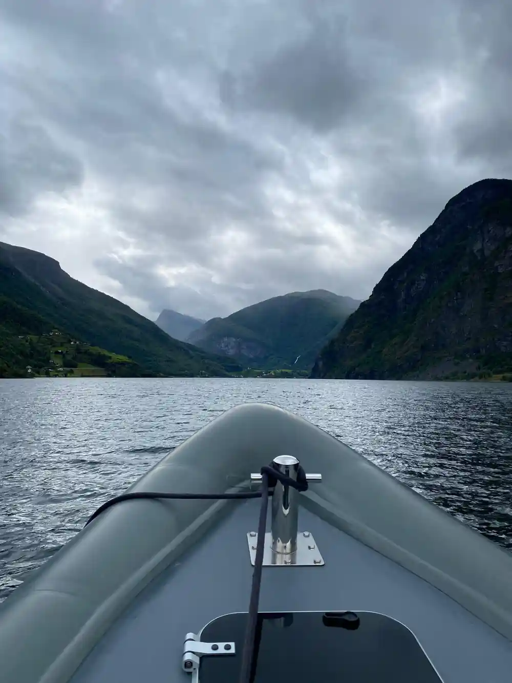 A dark headland ahead of the boat under cloud