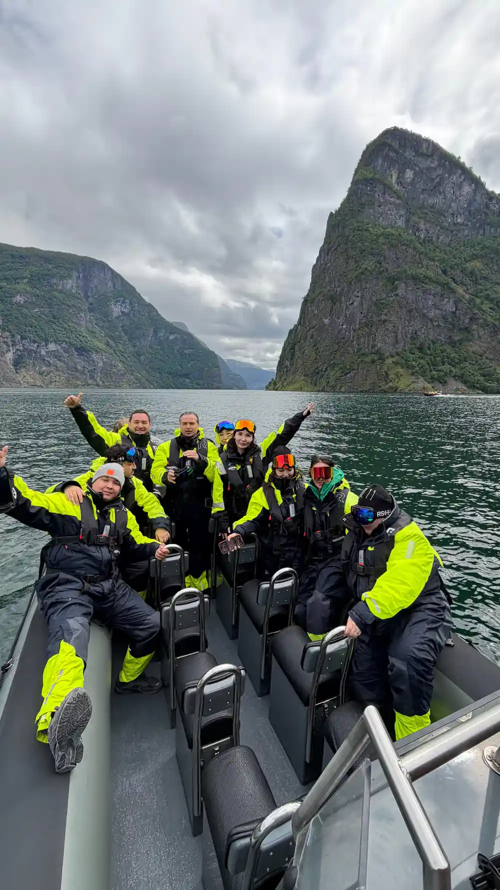 Passengers cheering with arms raised in the boat