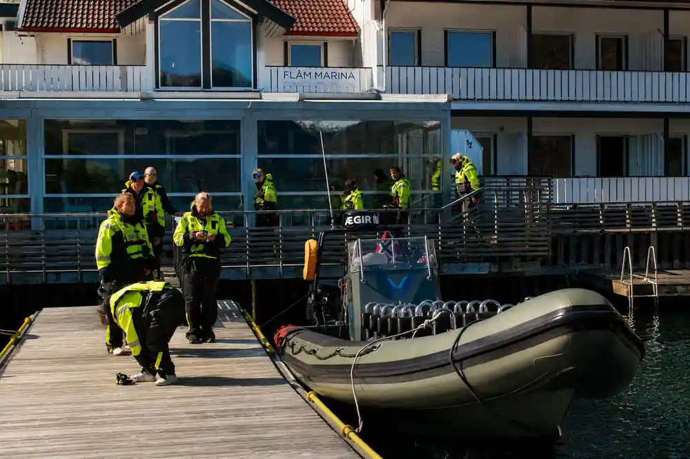 Passengers in suits gathered on the deck outside the marina building