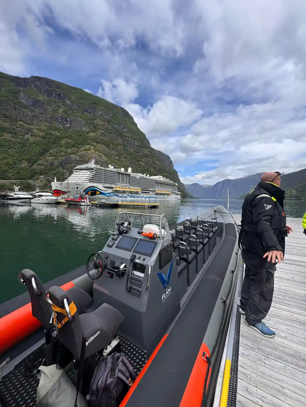 The RIB alongside the pontoon with a cruise ship in the background