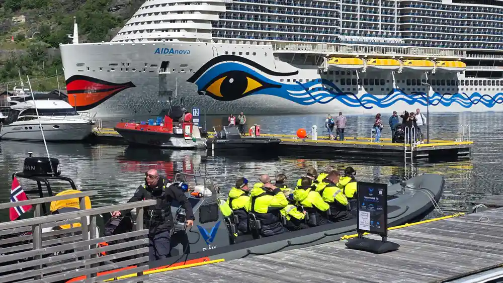 The RIB at the pontoon with a large cruise ship behind it