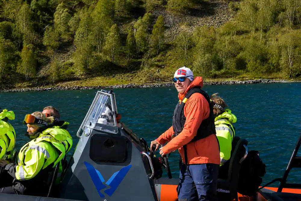 The skipper at the wheel of the RIB with passengers behind him