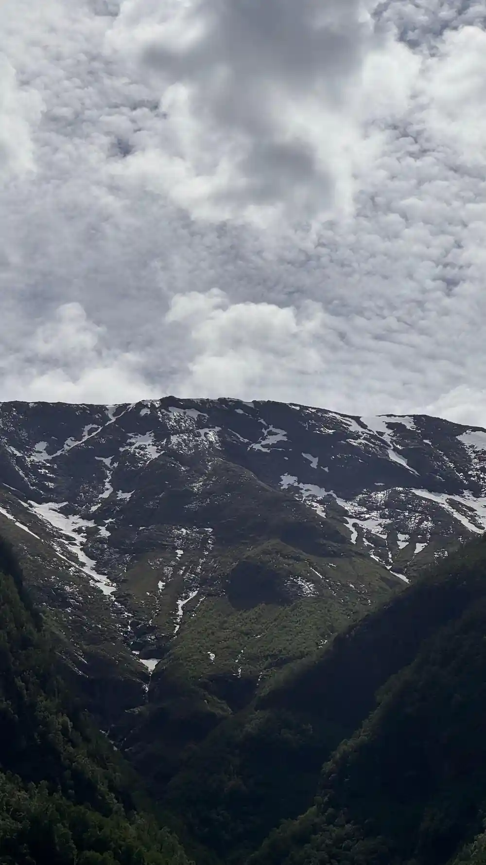 A snow-streaked ridge under grey cloud
