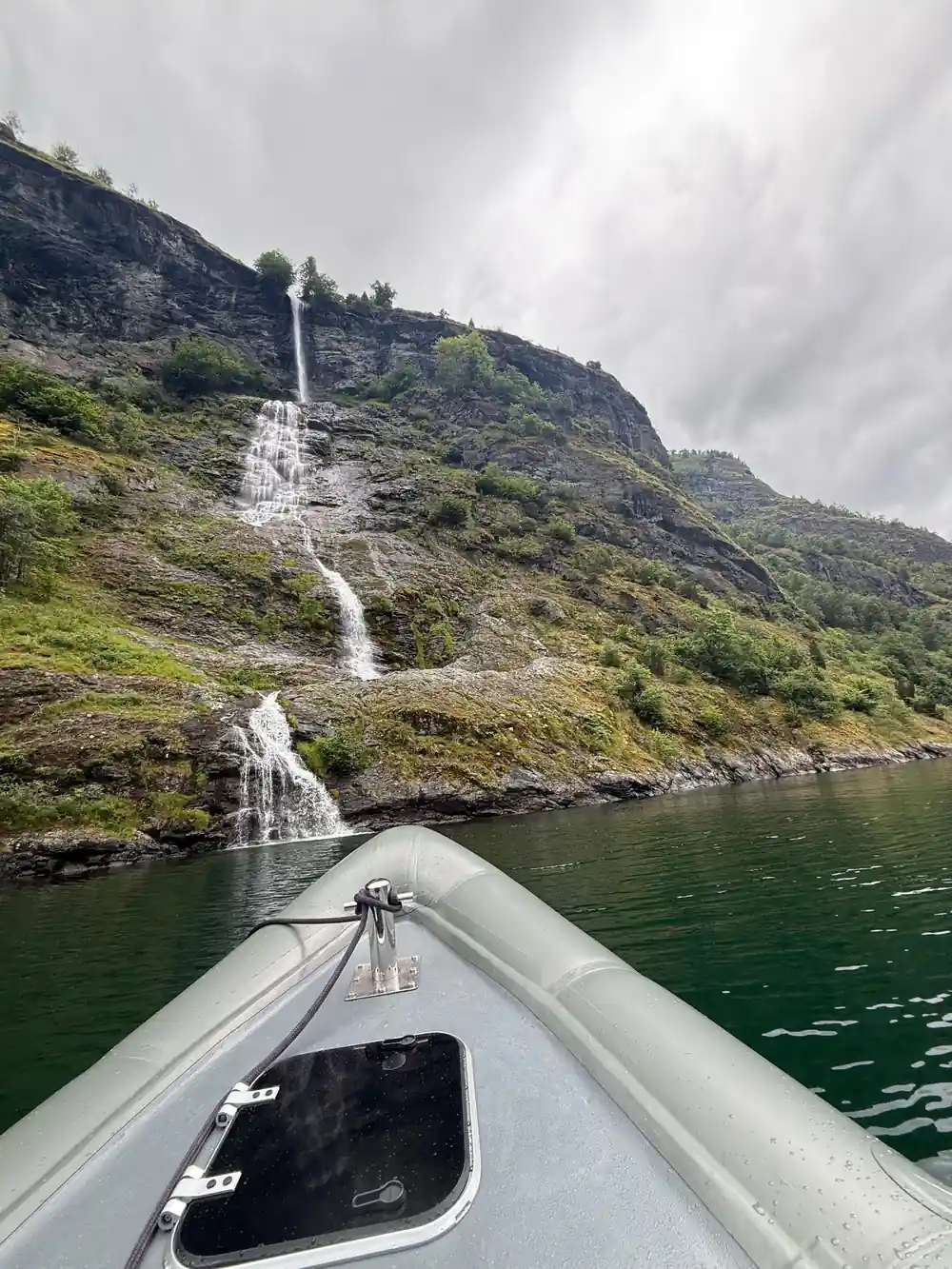 A thin waterfall on a green wall seen over the inflatable collar