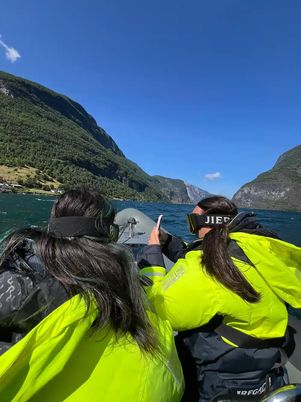 Two passengers photographing the fjord from the moving boat