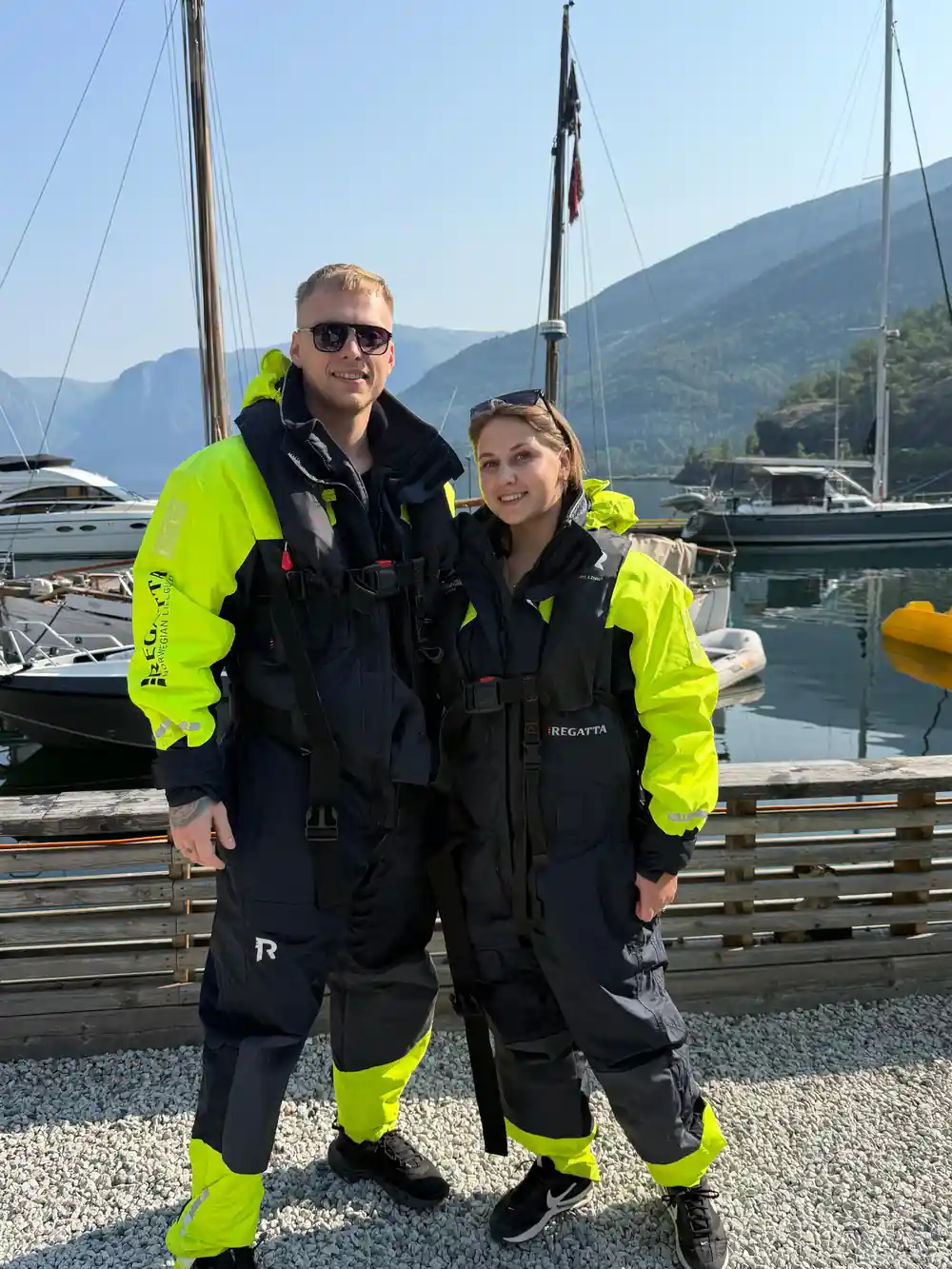 Two passengers in survival suits at the marina before boarding