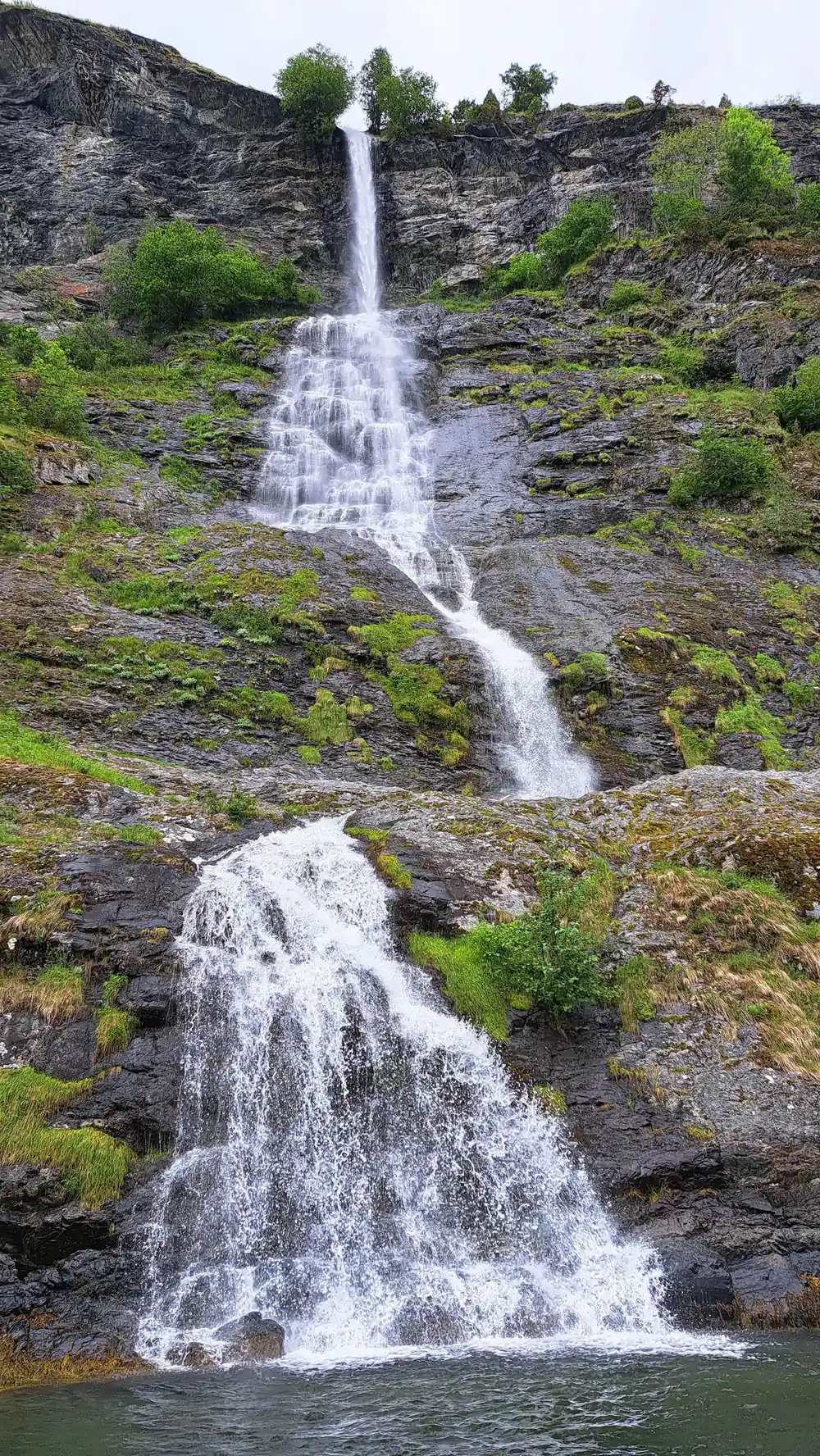 A waterfall dropping in two stages over mossy rock